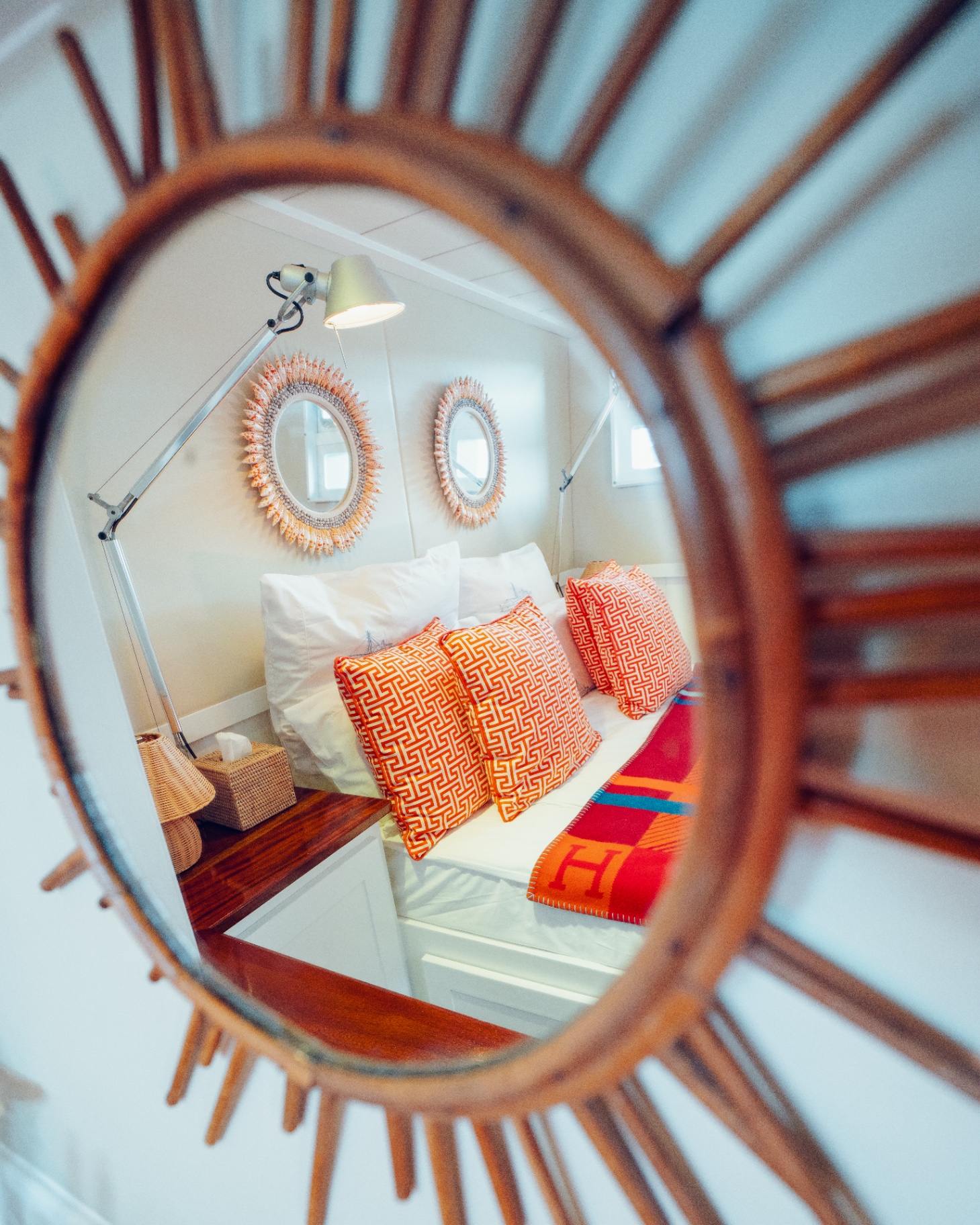 Cabin reflected through a rattan sunburst mirror