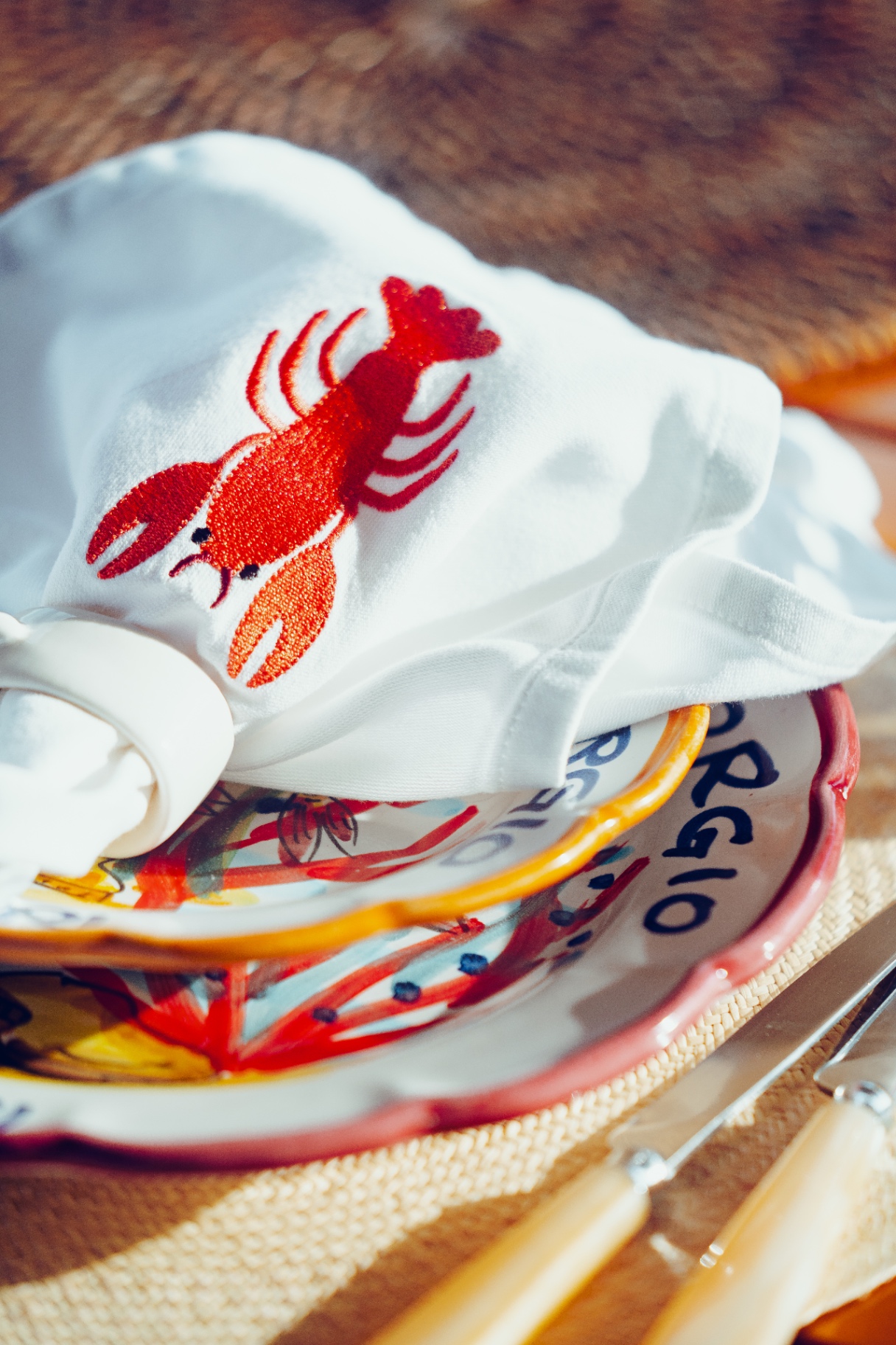 Lobster-embroidered linen and Amalfi plates